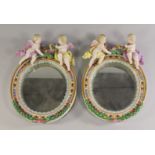 A pair of German porcelain oval mirrors, late 19th/20th century,