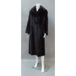 A full length dark brown mink coat, by Maxwell Croft, shawl collar and concealed front fastening,