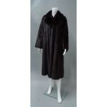 A dark brown full length mink coat, by Grosvenor, flared sleeves and concealed front fastening,