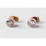 A pair of diamond ear studs, approx 0.70ct total, collet set in unmarked white and yellow metal.