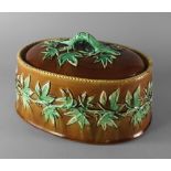 A Continental majolica tureen dish and cover, 19th century, the lid with loop handle with leaves,