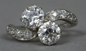 A platinum and diamond crossover ring
The twin claw set stones flanked by diamond set shoulders.