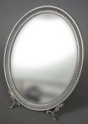 A Continental silver dressing table mirror
Of oval form, with scroll cast feet, stamped 800.