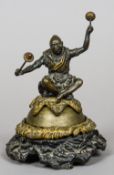 A 19th century patinated bronze table bell
Modelled as a  native figure seated on an animal skin