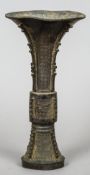 A 19th century Chinese patinated bronze vase
Of flared conical design with incised decoration.