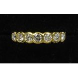 An 18 ct gold seven stone diamond ring
Of band form, with pierced shoulders.