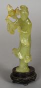 A Chinese carved jade figure of Guanyin
Modelled in flowing robes holding a flower,
