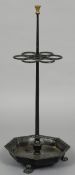 A cast iron sticks stand
Of free standing form with six stick apertures above the octagonal tray