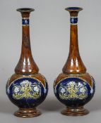 A pair of Doulton Lambeth pottery vases
Each with tall slender neck, the bodies typically decorated,