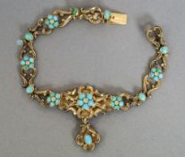 A Victorian gilt metal bracelet
Set with turquoise flowerhead decorations.  16 cm long.