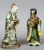 A Japanese porcelain figure of a sage
Modelled striking a gong; together with another,