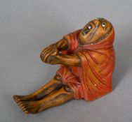 A late 19th/early 20th century Japanese carved wooden figure
Modelled seated in a red robe with