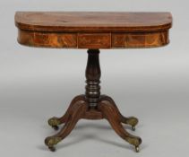 A Regency brass inlaid rosewood card table
The line inlaid revolving folding rounded rectangular