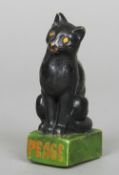 A World War I pottery peace emblem
Formed as a black cat seated astride a green painted plinth