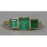 An 18 ct gold emerald set ring
The square cut emeralds in pierced setting.