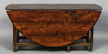 A large 18th century oak gateleg table
The oval twin flap top above twin frieze drawers,