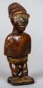 A small African carved wooden tribal figure
With inset glass eyes.  19 cm high.