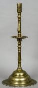 A large 18th century brass candlestick
With central drip pan and a large stepped spreading plinth