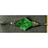 An Art Deco white gold and green jade bar brooch
Of carved lozenge form.  5.25 cm wide.