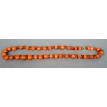 A string of coral beads
Mounted with a gold clasp.  38 cm long.