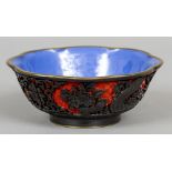 A Chinese red and black cinnabar lacquered bowl
Worked with floral sprays and lotus strapwork,