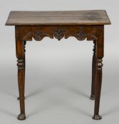 A 18th century carved oak side table
The moulded rectangular top above the carved and shaped frieze,