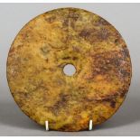 A Chinese carved hardstone bi-disc
One side with elements of a carved motif.  19 cm diameter.