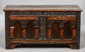 A 17th century  and later specimen wood inlaid oak coffer
With carved and arched panel front.