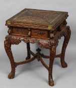 A late 19th century Chinese carved envelope card table
The hinged revolving top decorated with a