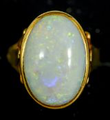 An unmarked 18 ct gold and opal ring
The cabochon stone set above the pierced shoulders.