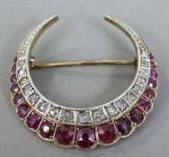 An unmarked gold, diamond and ruby set crescent form brooch
3 cm wide.