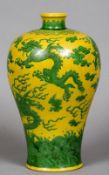 A Chinese porcelain Meiping vase
Decorated in green enamels with dragons and clouds on a yellow