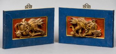 A pair of Chinese carved wood and gilt decorated temple dogs
Each in fabric covered frame,
