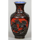 A Chinese red and black carved cinnabar lacquered vase
Worked with floral vignettes on lotus