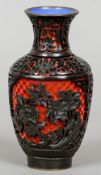 A Chinese red and black carved cinnabar lacquered vase
Worked with floral vignettes on lotus