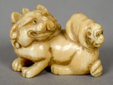A 19th century Japanese carved ivory netsuke 
Formed as a dog-of-fo with a monkey on its back.