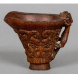 A carved horn libation cup
The handle a mythical beast, the body with archaistic band.  9 cm high.