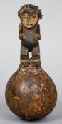 An African tribal rattle
Formed as a carved figure mounted on a gourd.  23.5 cm high.