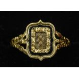 A Georgian unmarked gold mourning ring
Centrally set with a hair plait bordered by an enamel band.