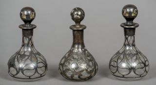 A pair of white metal overlaid glass scent bottles and another
All typically worked.  11 cm high.