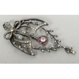 A Victorian unmarked diamond and ruby set pendant brooch
Of pierced trailing foliate form.