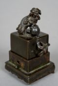 A 19th century Chinese patinated bronze box seal
Mounted with a dog-of-fo final,