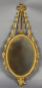 A 19th century Adam style giltwood wall mirror
The oval plate surmounted with bow tied trailing