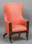 A William IV mahogany framed upholstered wing back armchair
The curved back above the padded arms