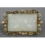 An unmarked gilt and white metal mounted carved white jade brooch
Centrally set and carved with