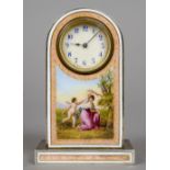 A pink enamel decorated desk clock
The white circular dial with Arabic numerals above a figural