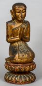 A Burmese gilt decorated carved wooden figure
Modelled at prayer.  51 cm high.