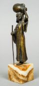 A cold painted bronze model of a North African woman
Carrying a jug on her head,