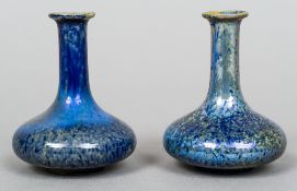 A pair of small high fired bottle vases
Each decorated with a blue lustre glaze.  Each 7.5 cm high.