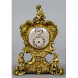 A small gilt bronze desk clock
With scroll cast and putto decoration with a silvered regulator dial.